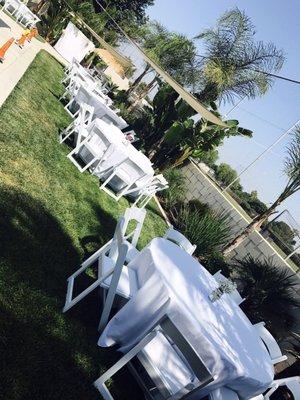 Round tables with white linen and white padded chairs.  Such a great look !