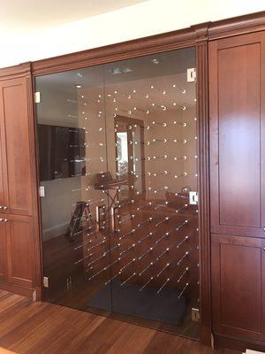 Dual doored wine storage enclosure using 3/8" clear tempered glass and heavy duty hinging hardware.