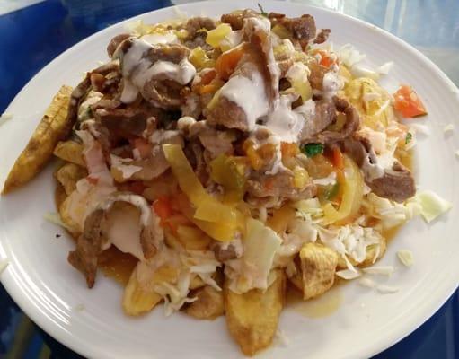 Honduran-style Steak & Potatoes with plantains, then shredded cabbage, onions, tomatoes, shredded beef, and creamy garlic sauce.