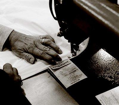 Sewing a tag onto a down comforter.