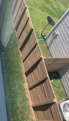 Upstairs view of the thin, bowing fence materials. This is after staining