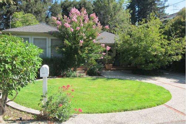 Inviting porch leads to winsome Dutch front door, large living room with many windows and gas fireplace.