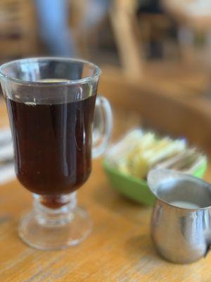 This is how coffee is served in this smooth glass cup