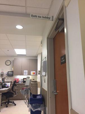 Another wooden door that bangs shut loudly every few minutes, the patients beds just a few feet away all in a small room.