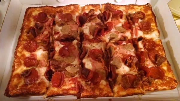 Meat lover type deep dish square pizza.