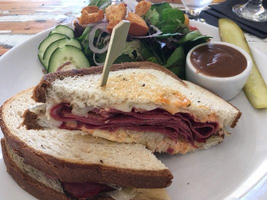 Pastrami Ruben sandwich with side salad