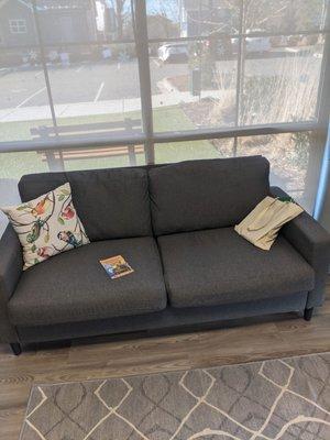 A comfortable couch in one of the cat offices where you can sit with your pet.