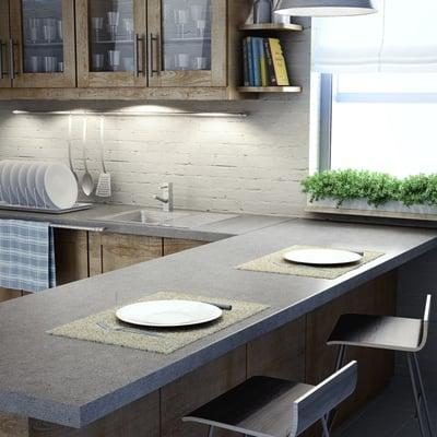 Creative kitchen finishes with polished concrete counter tops and painted, exposed brick.