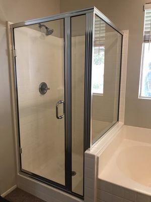 Framed shower enclosure with semi-frameless door