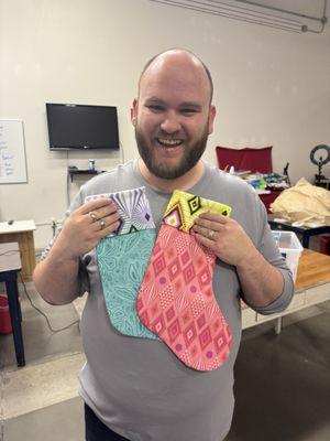 Keegan showing the gorgeous Christmas Stocking projects for the Serger Club at Going Batty. Tula Pink Fabric & Minke. Love it!   Julie A