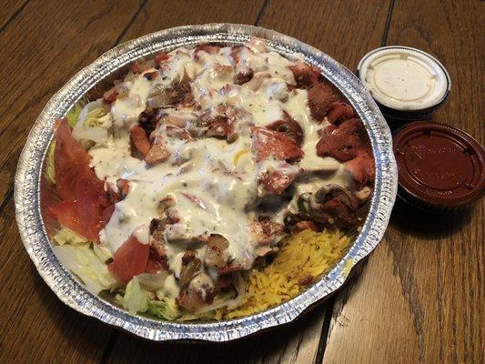 Halal chicken over rice with extra white sauce and hot sauce.