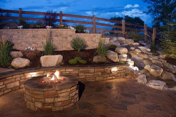 3 rail fence, retaining walls, low voltage lighting, fire pit, veneer stack stone, and a beautiful water feature.