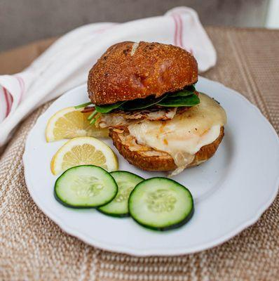 Egg, bacon, turkey, white cheddar, spinach, fig jam, on toasted pretzel bun