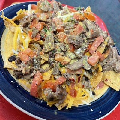 That nacho cheese sauce with a hint of curry is a match made in heaven!Carne asada, pico de gallo, black beans, and cheddar and jack cheese