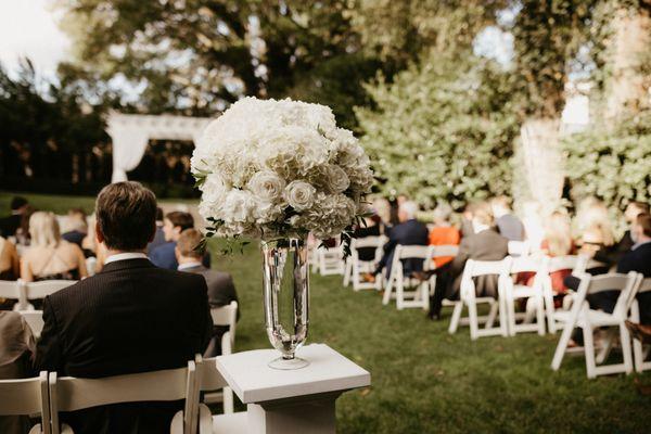 Ceremony floral arrangement on white wood pedestals (available for rent).  photo from Avonne Photography.