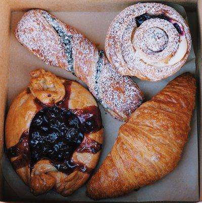 From top right: blueberry lemon cruffin, croissant, grape concord tart and chocolate twist