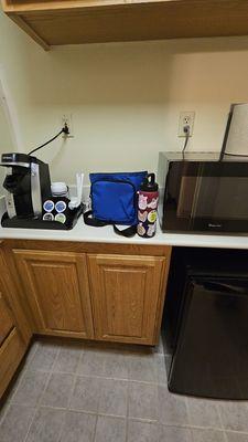 Fridge (and small freezer area inside), microwave, coffee, and out of view is a sink