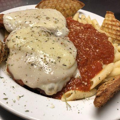 Classic Chicken Parmesan dinner lathered in marinara sauce sprinkled with Parmesan cheese served with garlic bread.