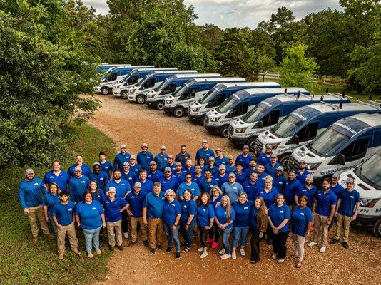 Our team standing proudly in front of our vans, showcasing our family-owned, local roots and friendly service.