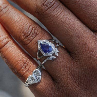 Blue sapphire Phoebe engagement ring in platinum stacked with the Unchained Naiad curved wedding band.