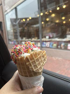 Vanilla ice cream on waffle cone with Rainbow Sprinkles.