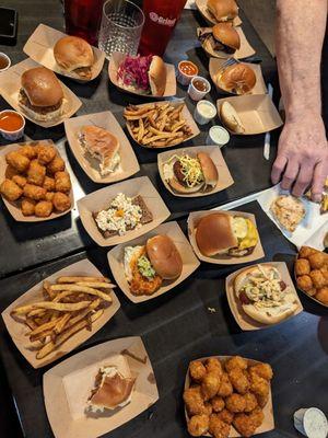 A variety of sliders, sauces, tots and fries