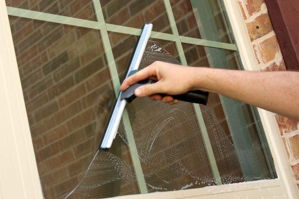 Squeegeeing a window involves using a rubber blade to remove excess water and cleaning solution from the surface of the window.