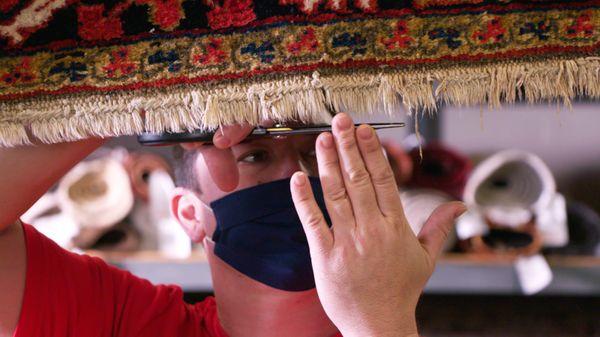 Trimming rug fringe. Each and every rug is carefully inspected and cared for by our professional rug cleaning crew.