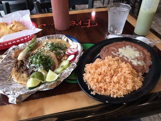 Grilled chicken and steak Mexican style tacos, rice and beans.