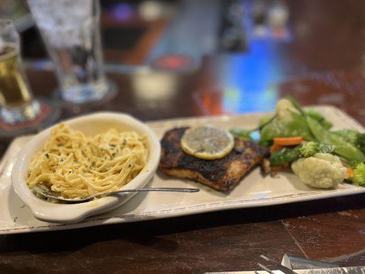 Wood fired salmon with veggies and angel hair pasta in a Parmesan cream sauce.