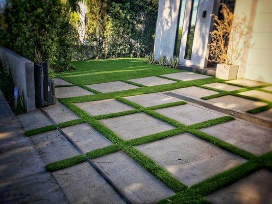 Artificial grass between concrete slabs - we have a line of grasses design for this type of installs.