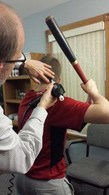 Adjusting the neck while the young patient swings his bat