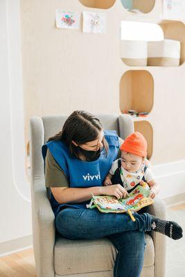 Teacher reading to a baby on campus