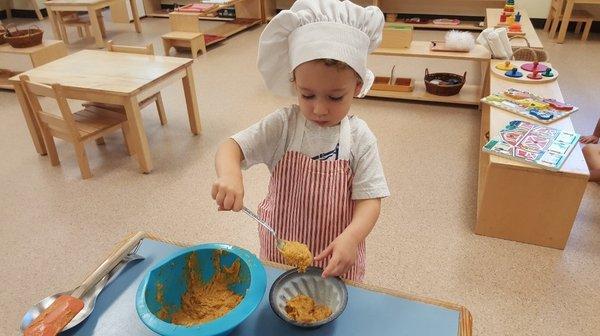 Toddler student making pumpkin bread! Independence is encouraged at all ages!