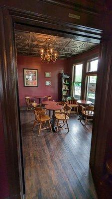 Back room with five two-seater tables and a restroom