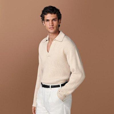 This sand buttonless polo sweater is tailored to a slim fit and features a ribbed texture, long raglan sleeves, and a classic polo collar.