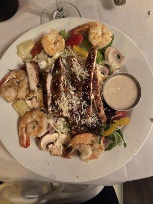 Mrs. Carole's salad topped with half shrimp half chicken