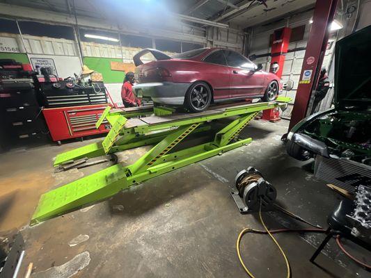 A lowered Acura Integra getting an alignment even though it's low our technicians can still get the job done!