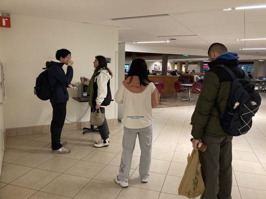 Line of people waiting for the only working microwave.