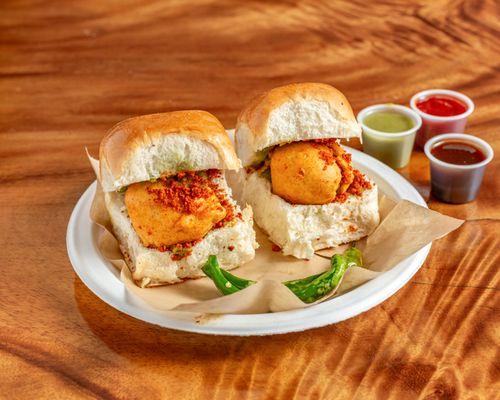 The dish consists of a deep fried potato dumpling placed inside a bread bun sliced almost in half through the middle.