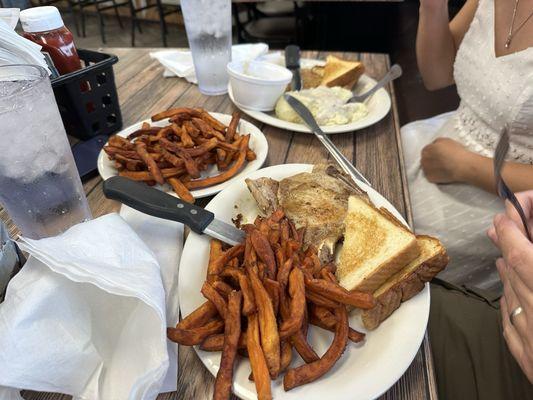 Grilled pork with a side of sweet potato fries.