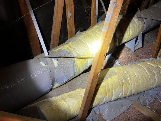 Torn and broken duct work in an attic