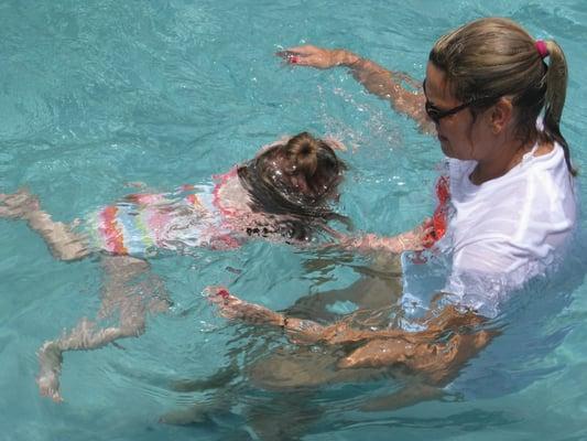 Ms. Cathy teaches children to swim on their own while remaining close by for safety.