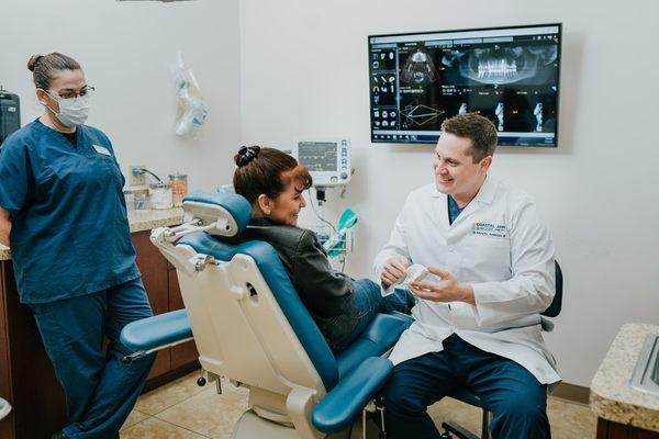 Dr. Kenneth L. Anderson III instructing a patient on her options for dental implants