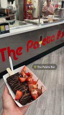 Coconut paleta dipped in Oreo with strawberries