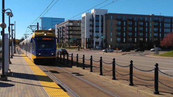 A blue line train is moving northbound in front of all sorts of new construction along American Blvd. in Bloomington.