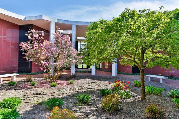 Blossoms from a Magnolia Tree and tulips, with the beautiful river rock, add tranquility to one of our atriums within Mausoluem Complex III