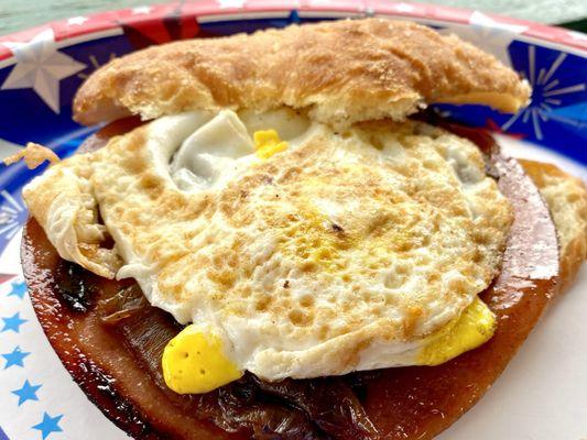 Fried balogna egg and sautéed onions on salty bread