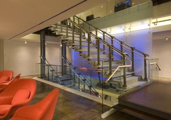 Frosted crystal film on glass wall next to suspended staircase.