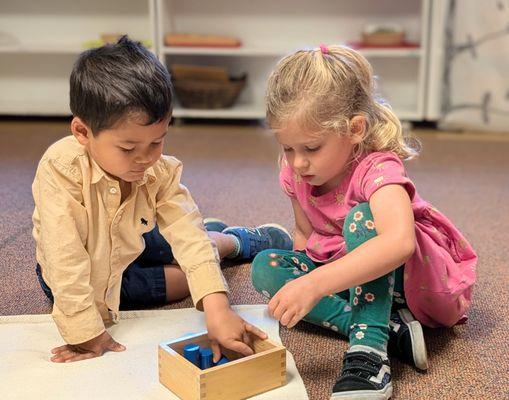 Two Kindergarten Bridge students work on the Knobless Cylinders.